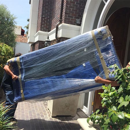 Crystal Coast Moving crew taking a furniture out of a house
