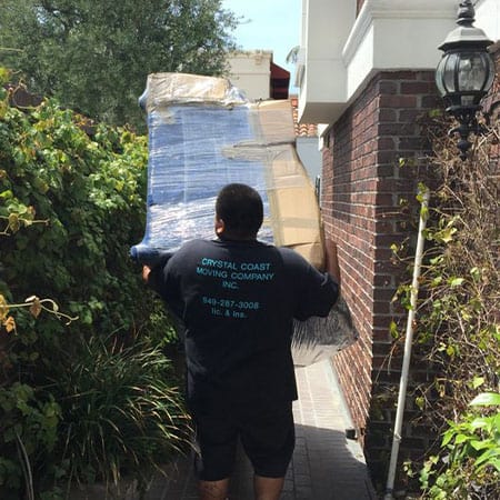 Crystal Coast Moving carrying boxes out of a house